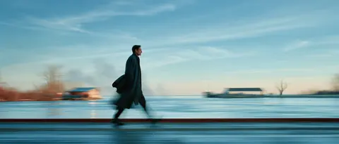 冬空下的渡口步行者 / adult walker carries a folded coat along an empty ferry landing, the · Panoramic