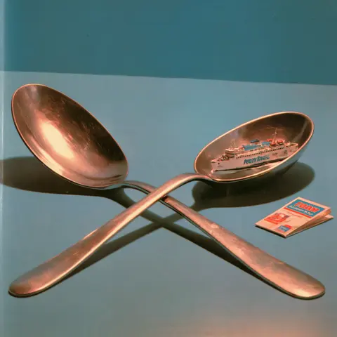 巨勺里的小渡船 / enormous spoon lies across a quiet tabletop with a tiny ferry boat resting · Square