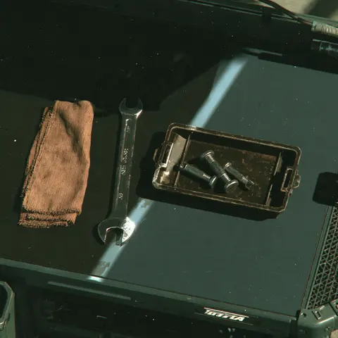 冷灰斜光的无人修理台 / overhead view of a mechanic's workbench with one wrench, a folded rag and a · Square